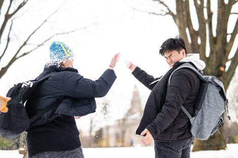 Two students have a snowball fight.