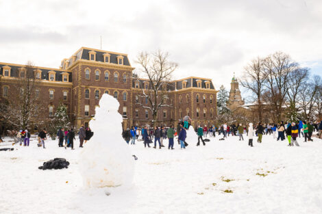 The Quad features several students and a snowman.