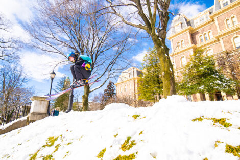 A Lafayette College community members skis down a hill.