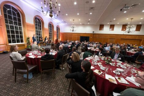 View of the attendees seated in Bergethon Room at the Scholarship Recognition Dinner. President Hurd and three students are seated on a podium.