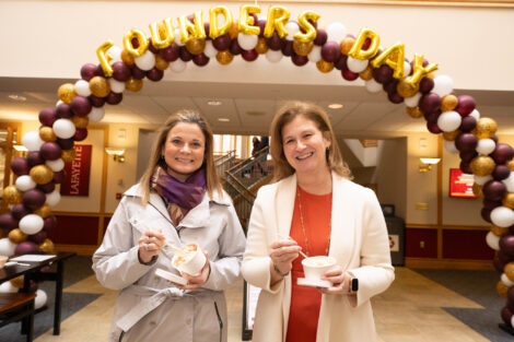 Executive Vice President of Administration Audra Kahr and President Nicole Hurd stand under a Founders' Day balloon arch.
