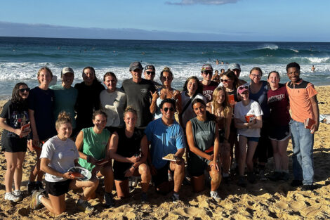 Students smile in front of scenic view in Hawaii.