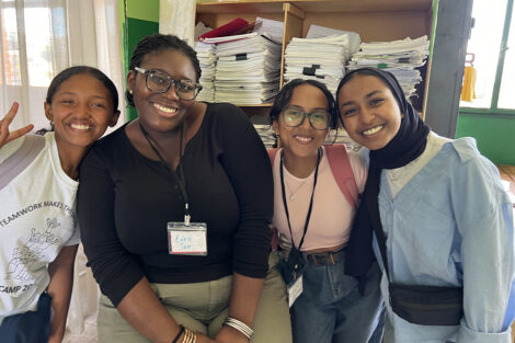 Students smile in a group of four.