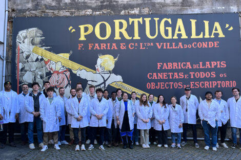 Students wear lab coats outside of a business in Portugal.