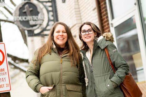 McKenna Graf ’26 and Sam Beedle smile outdoors in front of Touchstone Theatre.
