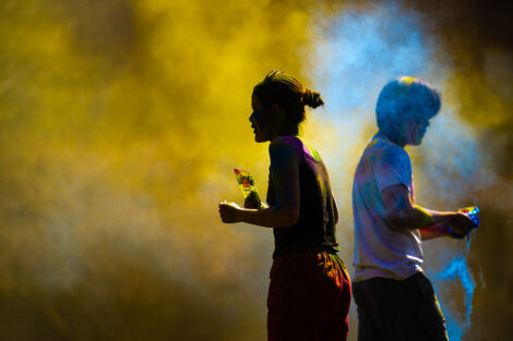 A student is seen in a fog of yellow powder at Holi Fest.