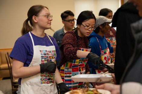 Two students serve food at the ISA food tasting event.