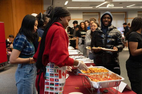 Students serve food at the ISA food tasting event; students are excited to participate and try various international foods.