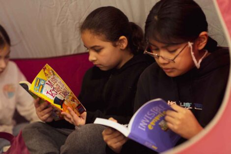 Students read books inside a tent during Literacy Day