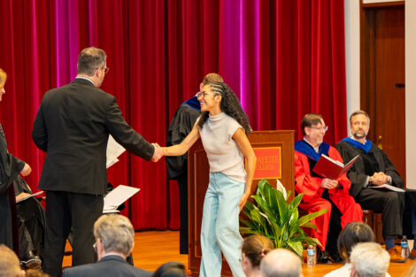 A student accepts an award on stage at Colton Chapel.