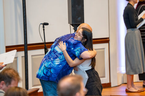 A student hugs a professor after accepting an award at Colton Chapel.