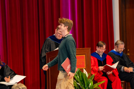 A student accepts an award on stage at Colton Chapel.