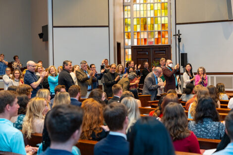 A crowd of faculty stand up to applaud awardees in Colton Chapel.