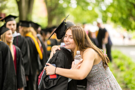 A family member hugs a graduate.