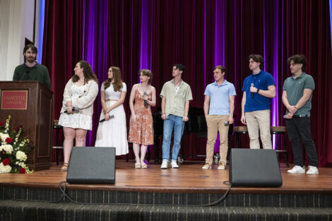 Students stand on stage