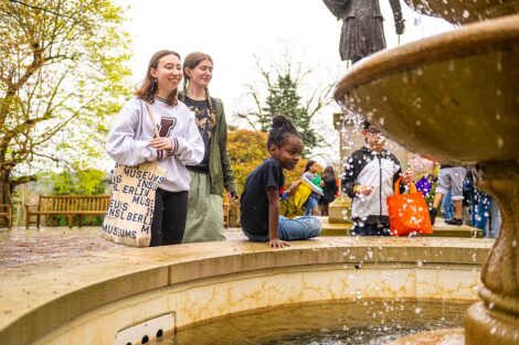 A group of EASD elementary school students pose with their college pen pals and peer into the fountain.