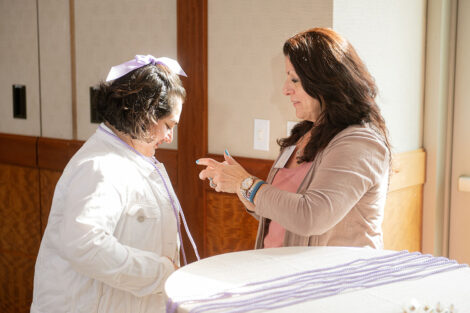 A student is given their lavender graduation cord.