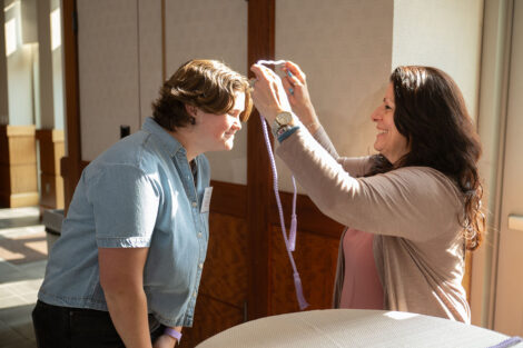 A student is given their lavender graduation cord.