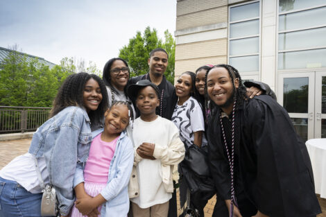 A family smiles with graduates.