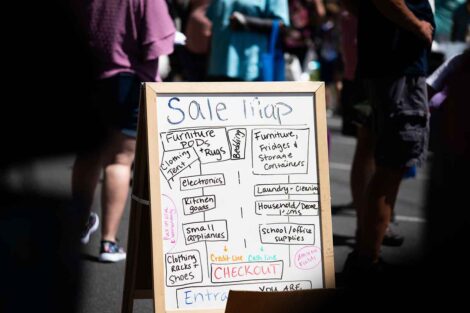 A whiteboard directs shoppers to the different areas of the sale through a Sale Map (for instance-bedding, clothing, etc.)