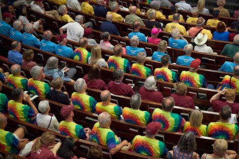 A view from above of the attendees at an event. They are seated and wearing different shirts to represent their class.