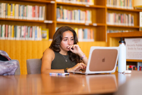 A student studies in Skillman Library, sitting with their laptop.