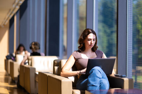 A student studies in Skillman Library, sitting with their laptop.