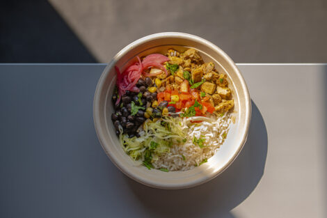 A burrito bowl from Cinco is shown on a table.