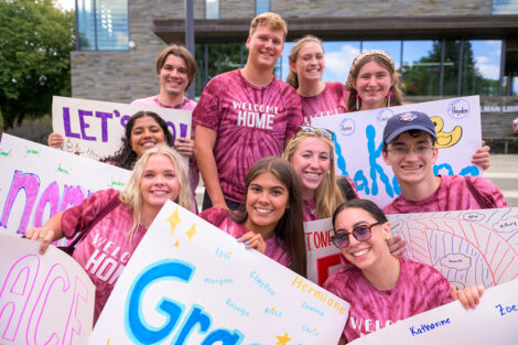 Students smile holding posters