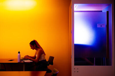 A student studies in the yellow light of the library.