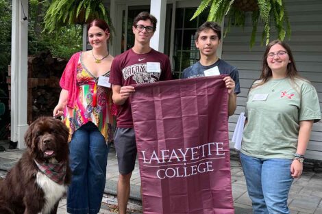 Incoming members of the Class of 2028 from Southern New Jersey are smiling at the camera. They are holding a Lafayette flag.