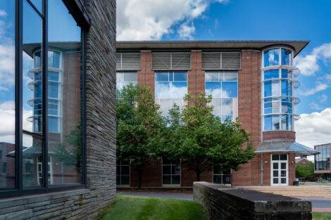 Hugel Hall's orange brick facade with modern adornments is reflected in the mid-century inspired architecture of Skillman Library.