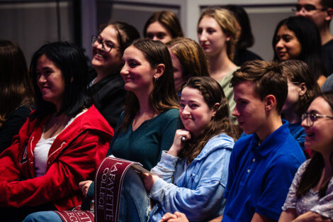 A student smiles in the crowd.