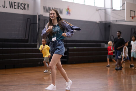 A student runs in the gymnasium.