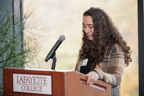 Coral Maizler Weston ’08 is standing at a podium.