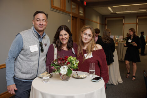 Three family members are at a table standing next to each other.