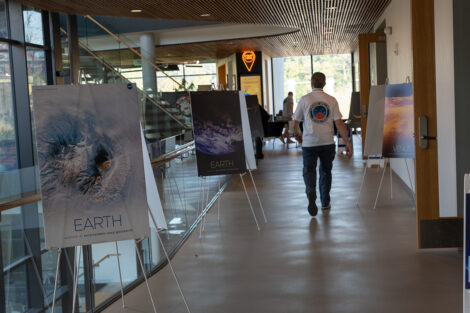 A view of RISC is shown with posters depicting planets and a man in an LV Space Fest shirt walking toward the festival.