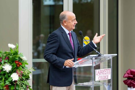 Bob Sell speaks at a podium outside the Simon Center.