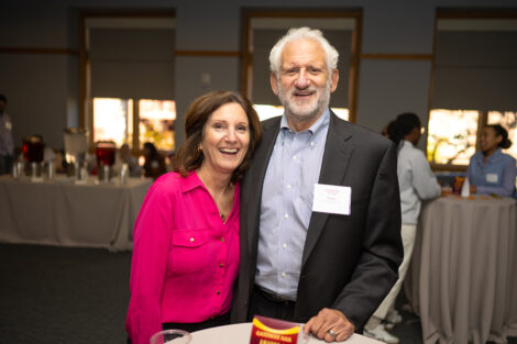 Joshua Werner ’79, is standing with his wife, Nancy. Nancy is wearing a pink shirt and Josh is wearing a dark jacket.