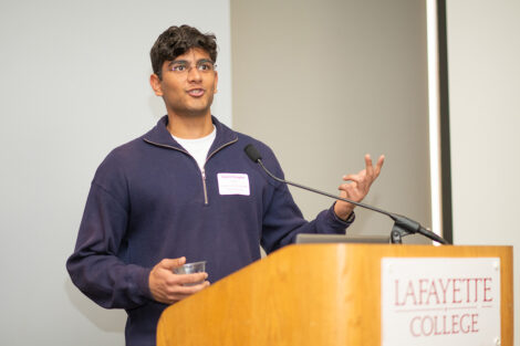 Kashif Chopra '25 is speaking behind a podium.