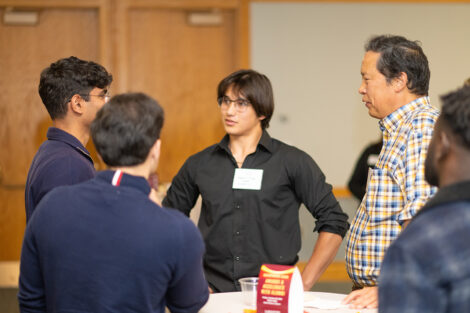 A group of students are standing and talking to each other.