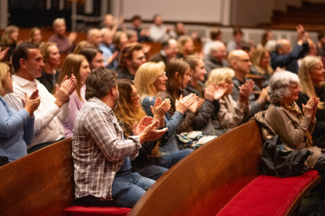 Audience members in Colton Chapel clap.