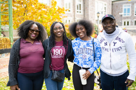 Four family members are standing on the Quad arm in arm.