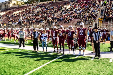 Members of the football team are standing on the sideline with Amanda Magadan Golini '17