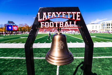 Photo of the Lafayette football bell located on the field. The sign above the bell reads 