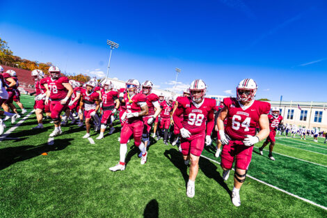 Members of the football team run on the field.