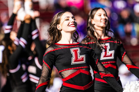 A cheerleader smiles and is dancing.