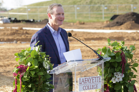 Andrew Wallach '95 is standing at a podium.