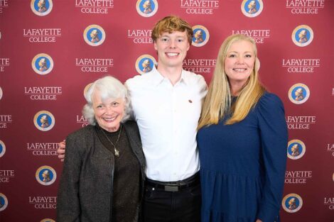 Three family members are standing in front of a Lafayette backdrop.