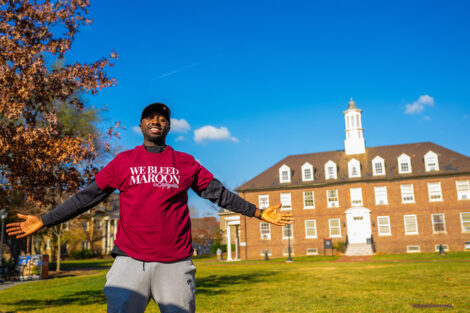 A student smiles in a We Bleed Maroon tshirt.